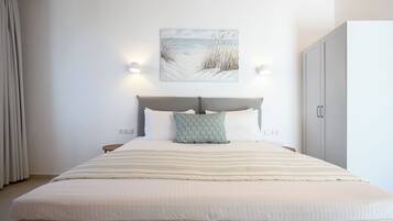 Ein Schlafzimmer mit einem großen Bett, einem Kopfteil, Nachttischlampen, einem Nachttisch und einem Kleiderschrank.