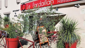 Un edificio con un cartello che riporta la scritta 'Le Pardaillan Restaurant Hotel'.