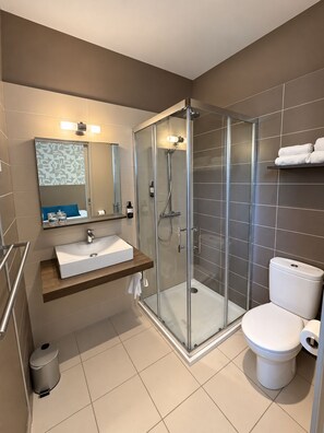 A modern bathroom with a glass-enclosed shower, a white sink, and a toilet. - Logis Hôtel Restaurant Le Pardaillan (Gondrin)