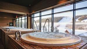 A spa area with multiple hot tubs and a view of a snowy landscape.