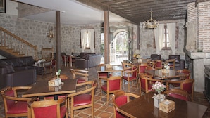 Un restaurante con paredes de piedra, muebles de madera y una escalera.