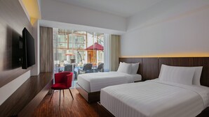 A hotel room with two beds, a TV, a desk, and a red chair. - The Bene Kuta Bali (Kuta)