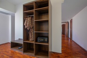 A walk-in closet with multiple shelves and a hanging rod, a pair of shoes, and a radio. - The Bene Kuta Bali (Kuta)