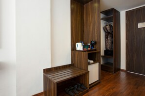 A room with a wooden wardrobe, a shoe rack, and a small cabinet. - The Bene Kuta Bali (Kuta)