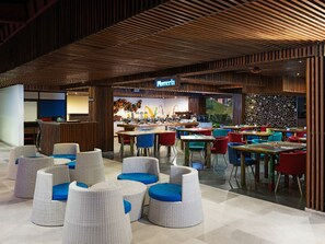 A modern restaurant with a wooden ceiling and a variety of seating options including wicker chairs and tables. - The Bene Kuta Bali (Kuta)