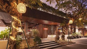 A modern building with a wooden facade, a sign reading "The BENE", and a well-lit entrance with steps leading up to it. - The Bene Kuta Bali (Kuta)