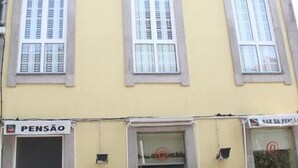 A yellow building with two ground-floor shops, one labeled 'PENSÃO' and the other 'BAR DA PENSÃO'.