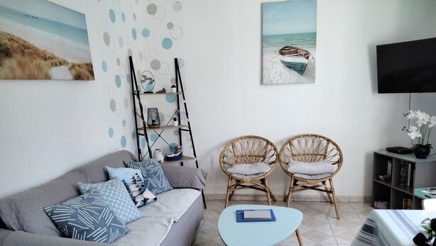 A living room with a sofa, two wicker chairs, a coffee table, a TV, and artwork on the walls. - CHARMING HOUSE - ALL COMFORTS - RATED 2 STARS (Le Crotoy)