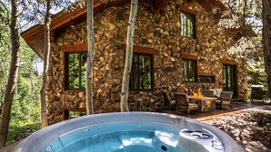 A stone cabin with a hot tub in front, surrounded by trees. - Easy Ski inOut-Private Home -NOT Condo or Townhome-in Upper DV-Silverlake (Park City)