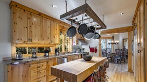 A spacious kitchen with wooden cabinets, a central island, and hanging pots. - Easy Ski inOut-Private Home -NOT Condo or Townhome-in Upper DV-Silverlake (Park City)