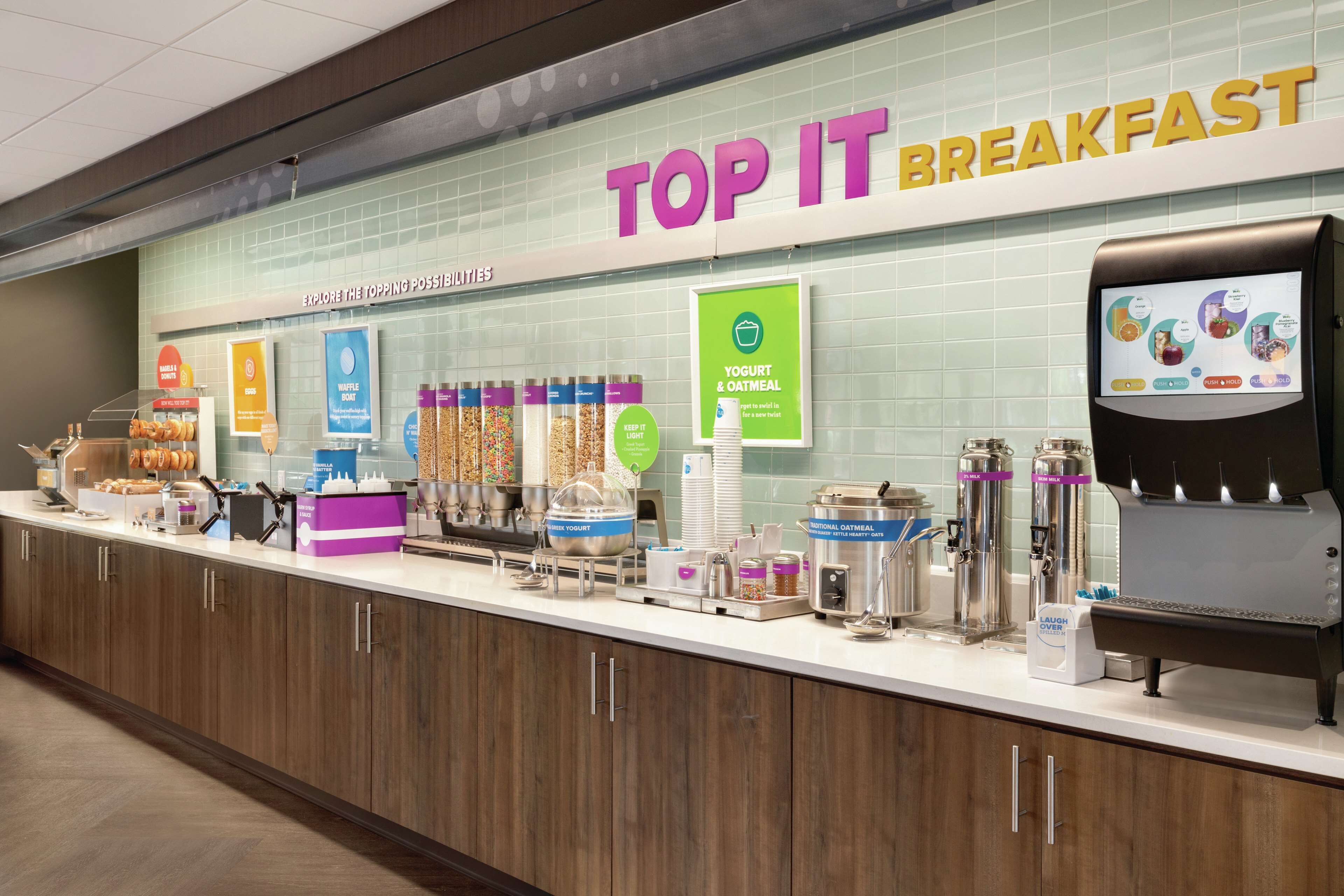 A breakfast area with a sign reading "TOP IT BREAKFAST" and various food options like yogurt and oatmeal.
