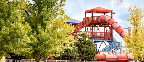 A water park attraction with a red slide and a flag.