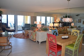Relax in a spacious living area with a large dining table and comfortable seating, surrounded by ocean views.