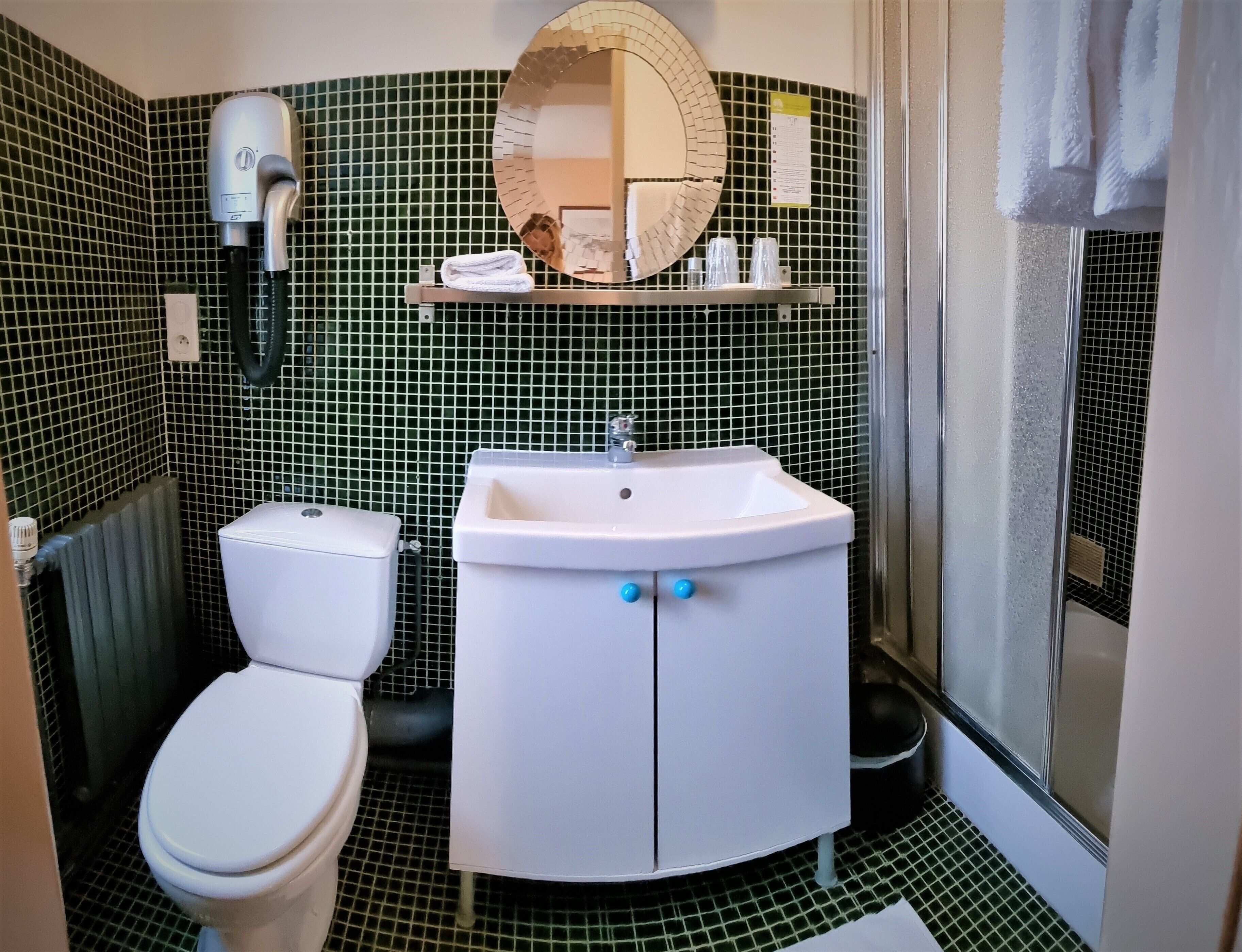 A bathroom with a toilet, sink, and mirror.