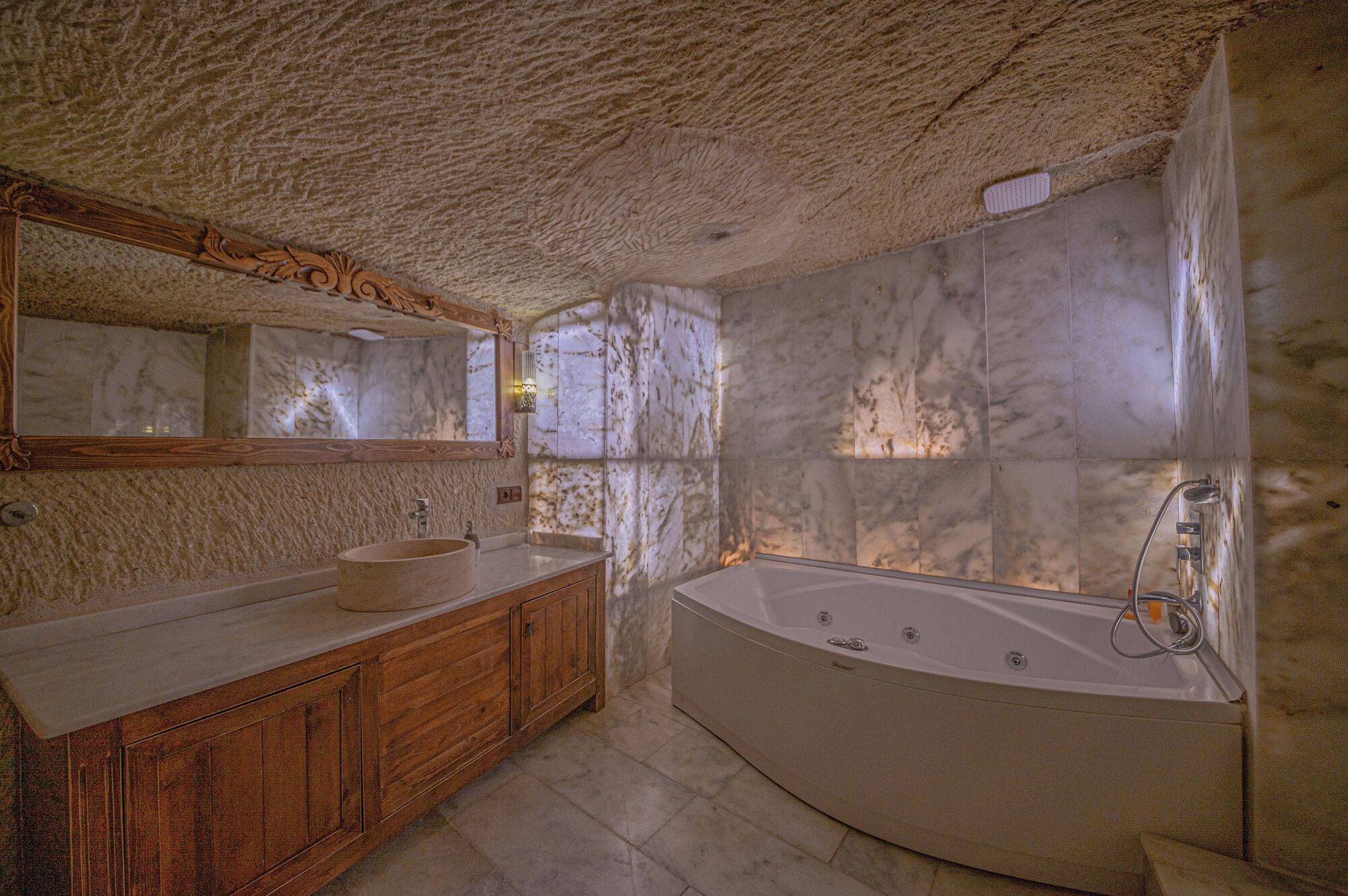 A bathroom with a marble vanity, a freestanding bathtub, and a large mirror.