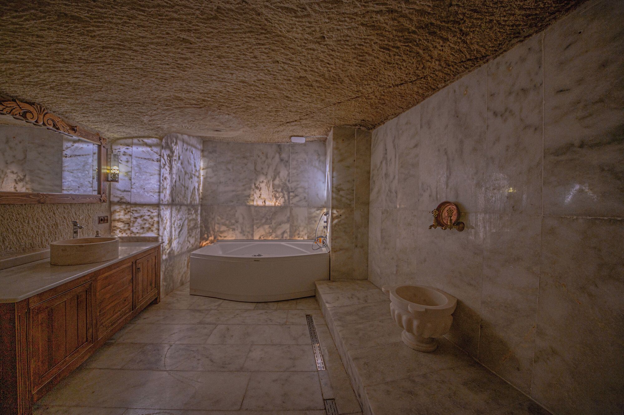 A bathroom with a marble sink, a freestanding bathtub, and a toilet.