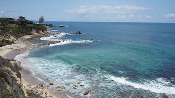 Uma praia costeira com afloramentos rochosos e águas azul-claras.