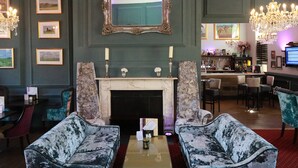 A bar area with a fireplace, bar stools, and a television. - Kings Newmarket (Newmarket)