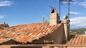 A rooftop terrace with a table and chairs, a chimney, and satellite dishes. - Authentic village house in the center of Ramatuelle (Ramatuelle)