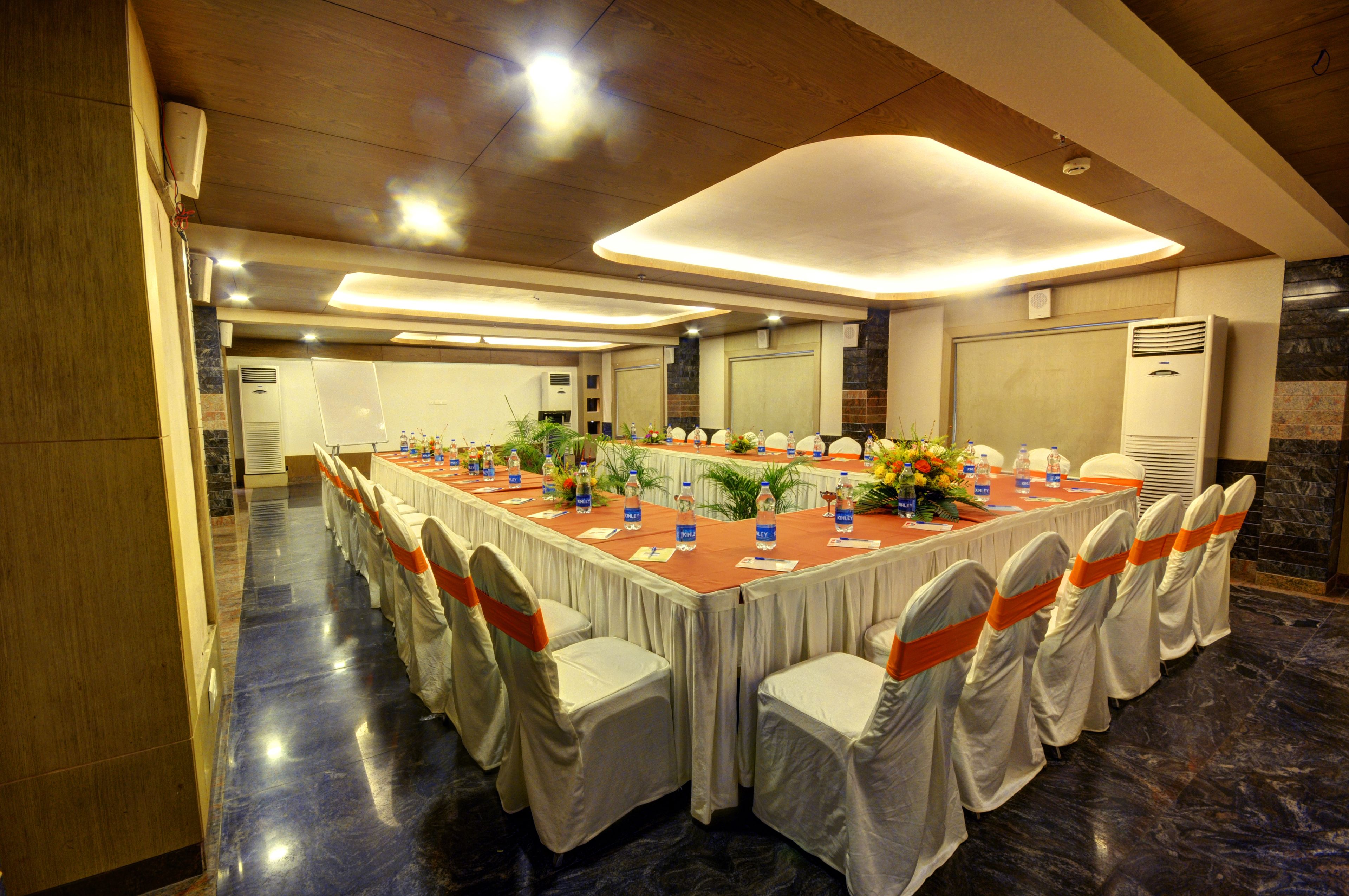 A conference room with a long table, chairs, and water bottles.