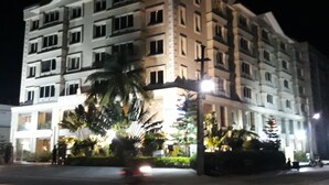 Um hotel com várias andares, fachada simétrica, janelas grandes e entrada central.
