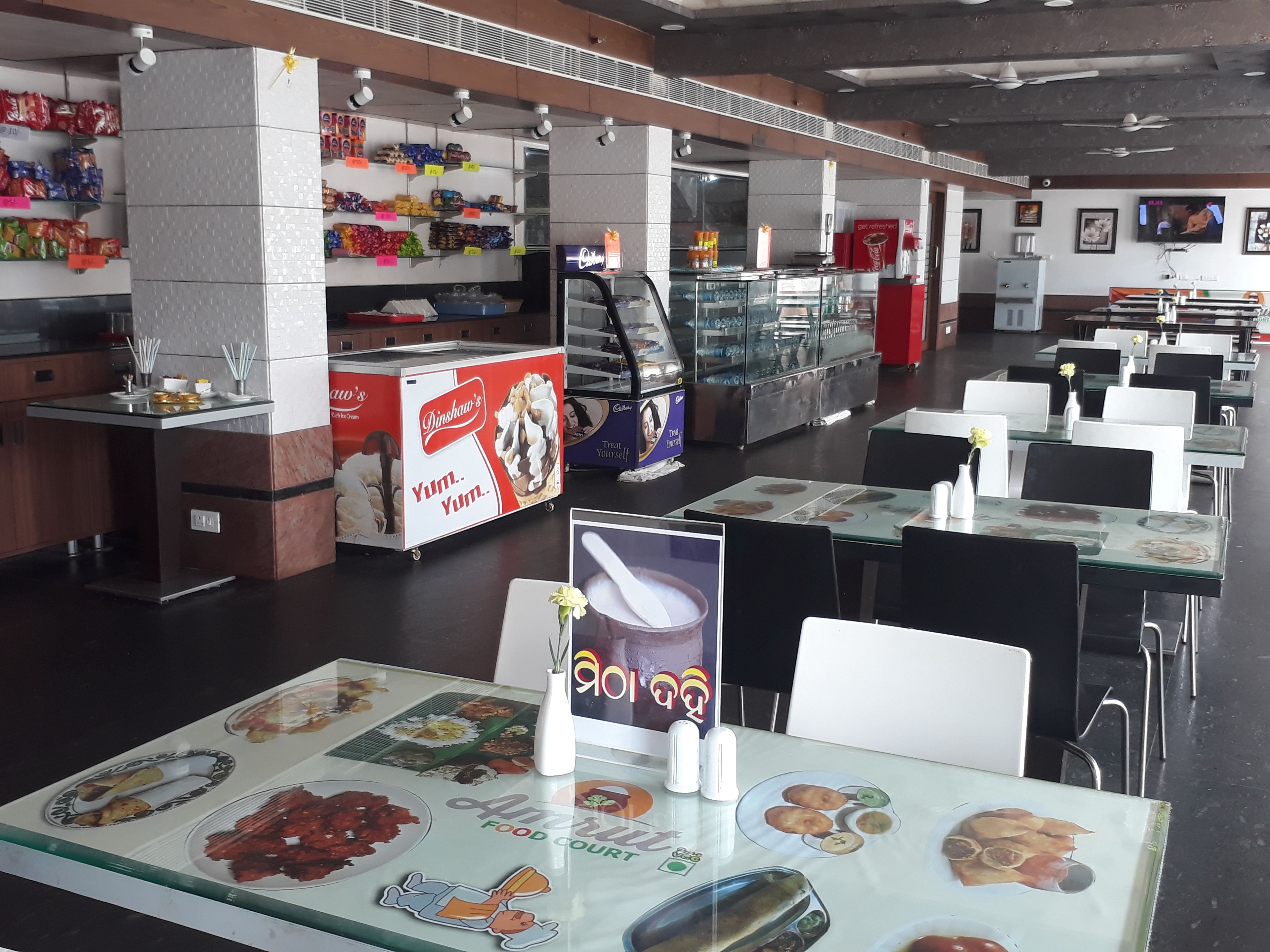A food court with tables, chairs, and various food vendors.