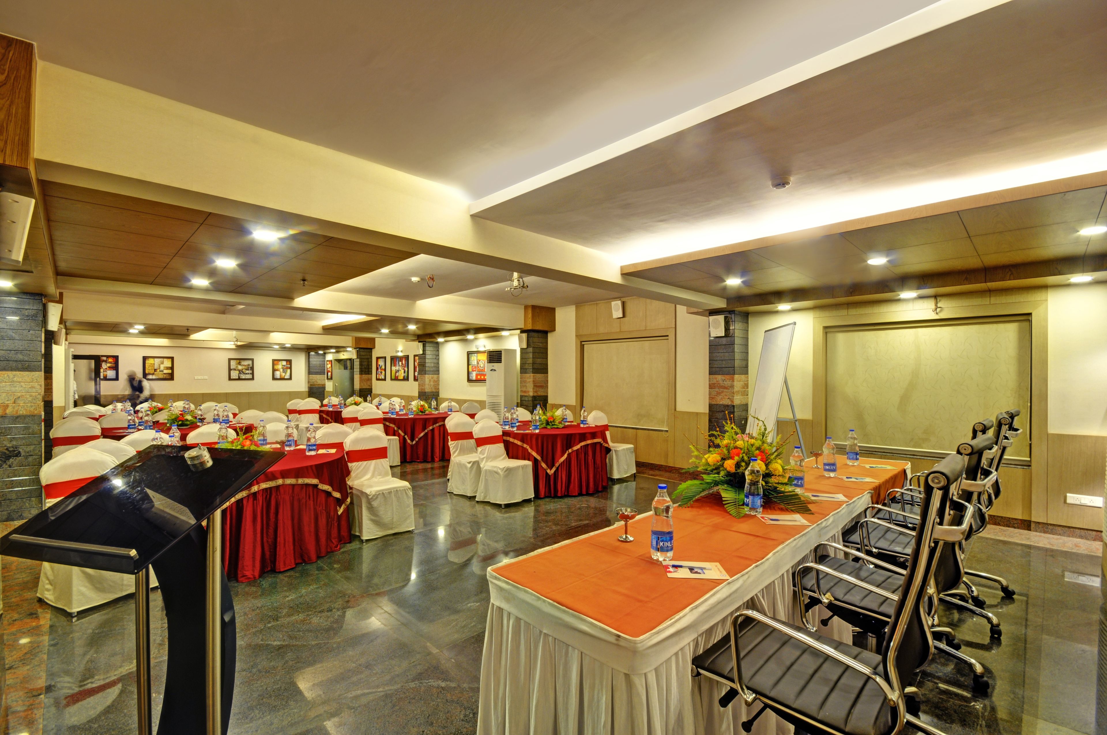 A conference room with a long table, chairs, and a stage.