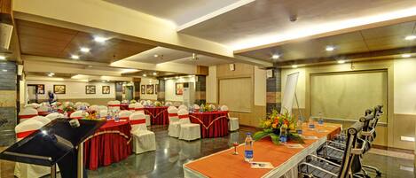 A conference room with a long table, chairs, and a stage.