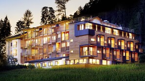 Un hôtel à plusieurs étages doté de balcons, de grandes fenêtres et d’une façade en bois.