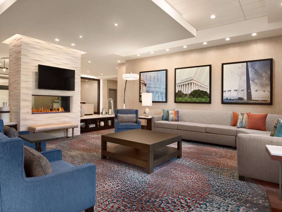 A modern living room with a fireplace, sofas, a coffee table, and artwork on the walls.