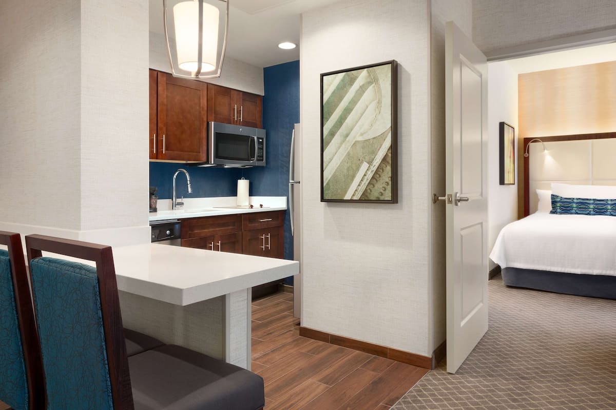 Une chambre d’hôtel comprenant un lit, une petite kitchenette et un coin repas.