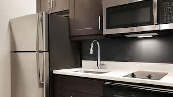 Una cocina moderna con electrodomésticos de acero inoxidable, microondas integrado y lavavajillas.