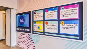 A bulletin board with various signs listing local attractions, bars, and shopping recommendations.