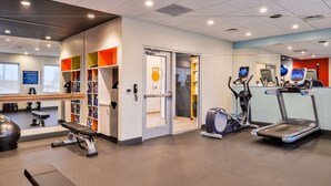 A modern gym with exercise equipment, a bench, and a mirrored wall. - Tru by Hilton Stuttgart, AR (Stuttgart)