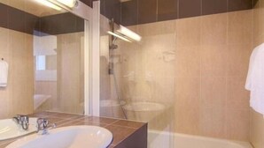 Un baño con lavamanos, espejo y ducha.