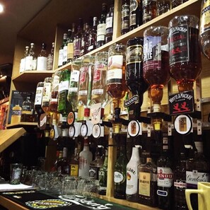 A bar with various bottles of alcohol and glasses on shelves. - Belgrave Arms Hotel (Helmsdale)