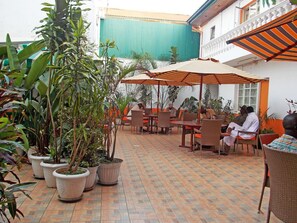 An outdoor patio area with potted plants, tables, and chairs. - Hanan Guest House (Nairobi)