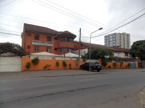 A building with a sign reading "HANAN GUEST HOUSE" and a black car parked in front. - Hanan Guest House (Nairobi)