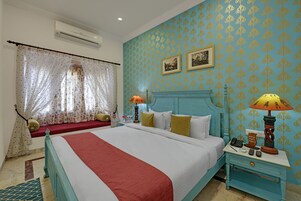 Una camera da letto con un letto, un comodino, una lampada e una finestra con tende.