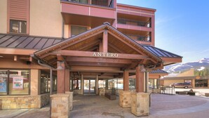 A hotel entrance with a covered area named "ANTERO," stone pillars, and a mountain backdrop. - Sky Mountain Studio (Breckenridge)