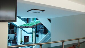 Ein modernes Hotelinnere mit einer Treppe, einem an der Wand befestigten Flachbildfernseher und einem Schild mit dem Namen des Hotels.