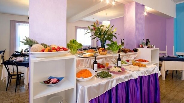 A buffet table with various food items and a decorative centerpiece. - Hotel Milano (Gatteo)