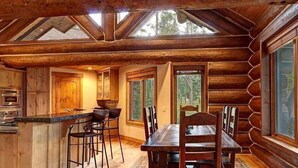 A log cabin interior with a kitchen, dining area, and large windows. - Big Timber Lodge (Breckenridge)