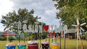 A garden with decorative cupcake signs and a windmill. - Norn Nee at Khaokho (Khao Kho)