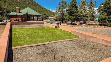 A building with a green roof, surrounded by a landscaped area with grass and gravel paths.
