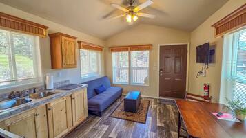 A compact kitchen with wooden cabinets, a built-in sink, and a ceiling fan.