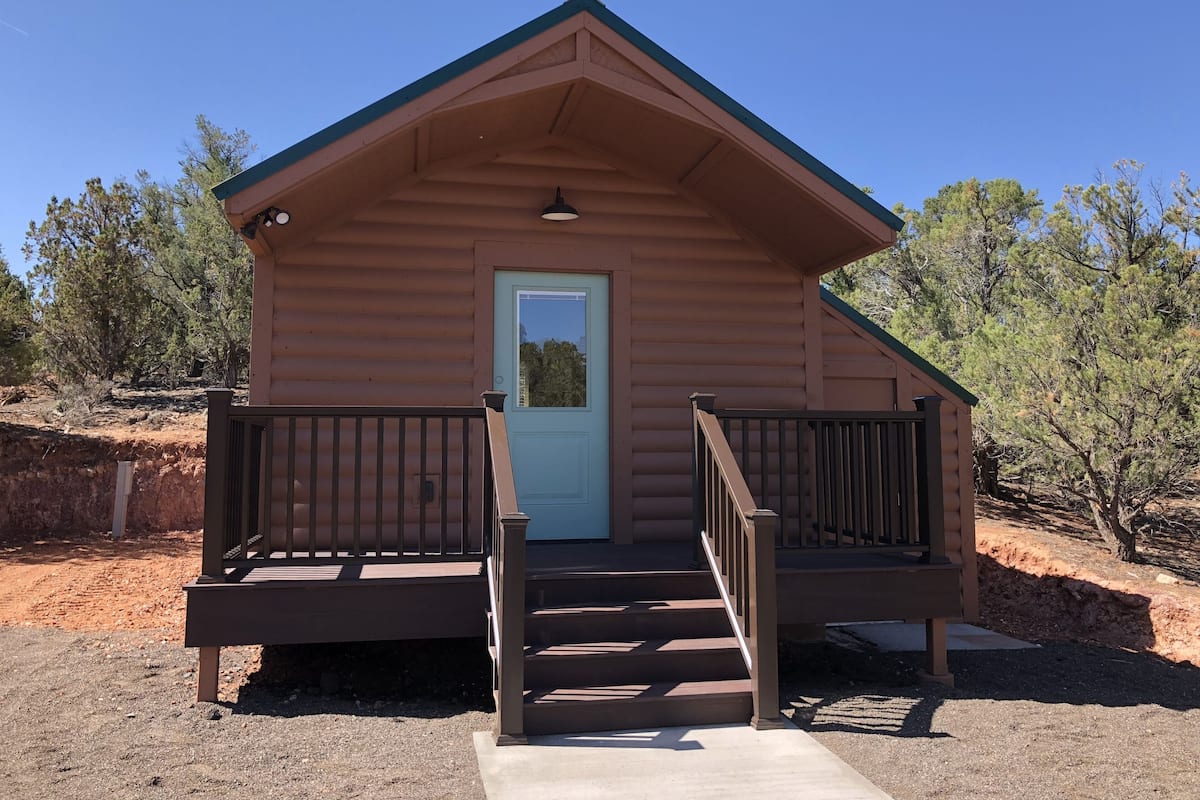 A small, single-story cabin with a front porch and a door.