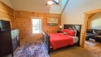 Une chambre à coucher avec un lit, une commode, un tapis, un ventilateur de plafond et une fenêtre.