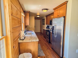 A kitchen with wooden cabinets, stainless steel appliances, and a granite countertop.