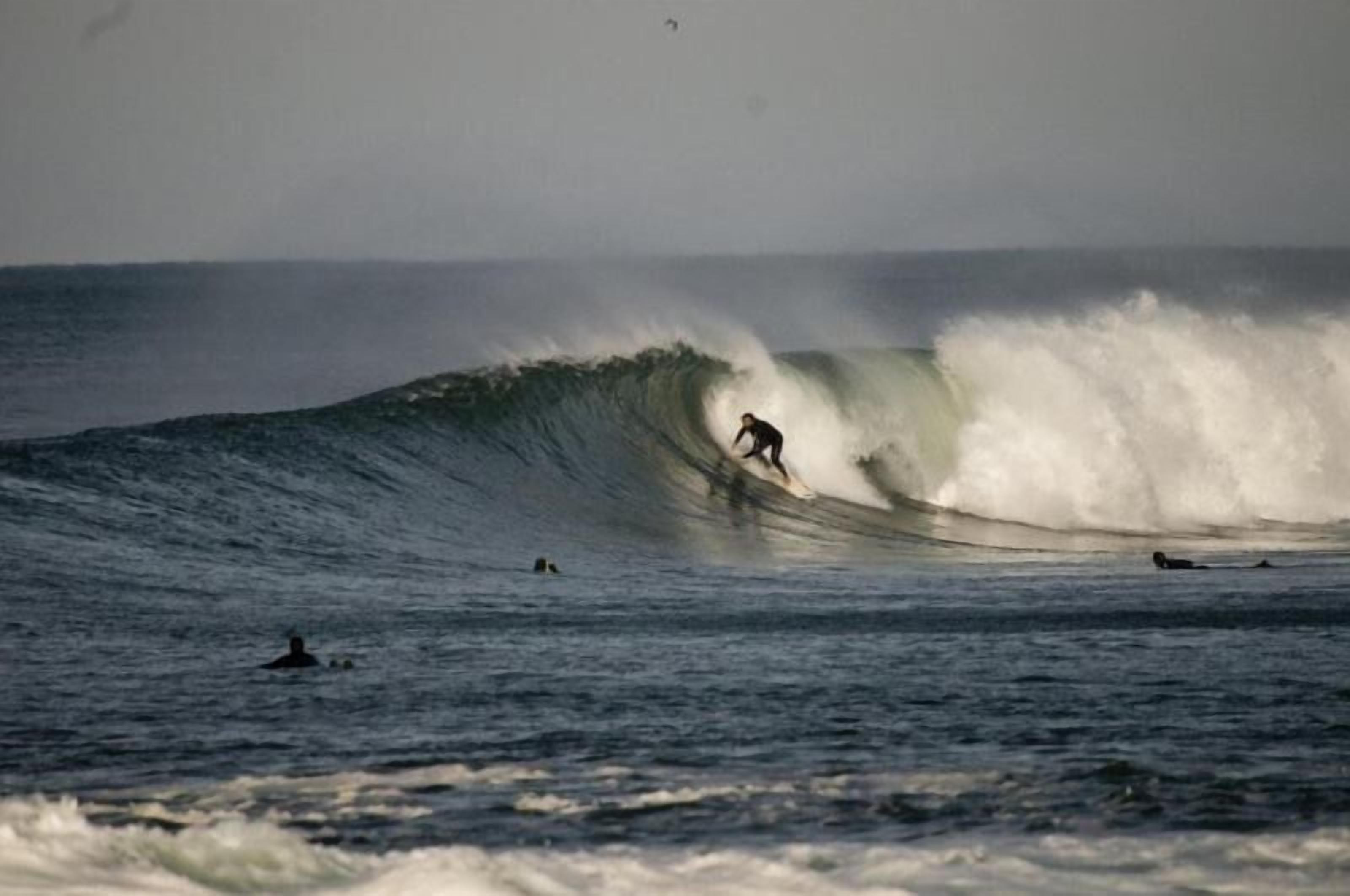 A surfer riding a large wave in the ocean.
